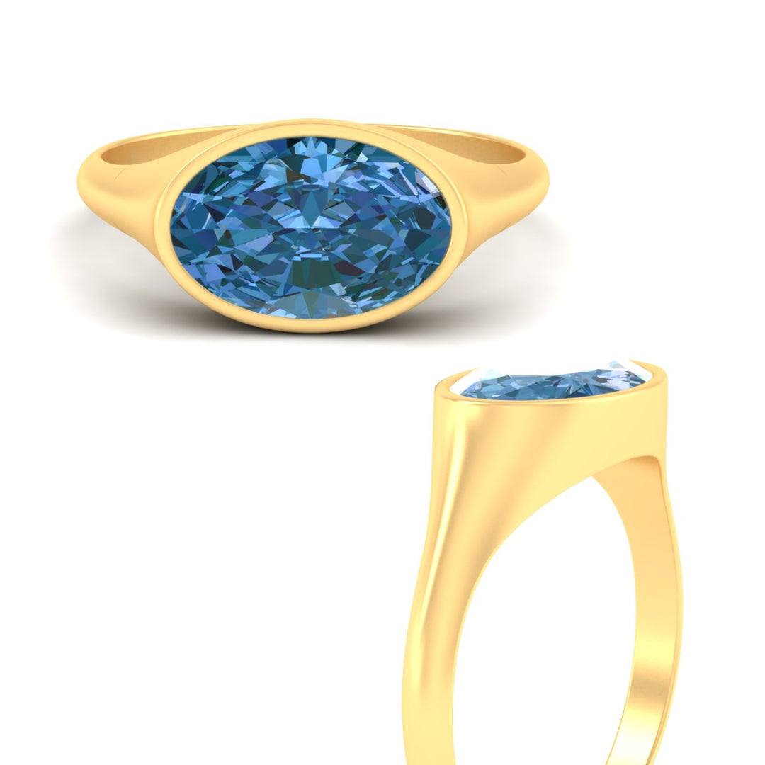 east-west-oval-bezel-vivid-blue-engagement-ring-in-yellow-gold-fdenr11606gvblueangle3-nl-yg.jpg?v=1789038603