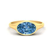east-west-oval-bezel-vivid-blue-engagement-ring-in-yellow-gold-fdenr11606gvgluesleep-nl-yg.jpg?v=1789038603