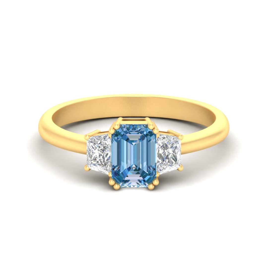 emerald-cut-vivid-blue-trapezoid-engagement-ring-in-yellow-gold-fdenr7981emgvbluesleep-nl-yg.jpg?v=1788347229