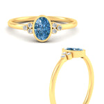 Load image into Gallery viewer, petite-bezel-set-oval-shaped-vivid-blue-engagement-ring-in-yellow-gold-fdenr9175ovgvblueangle3-nl-yg.jpg